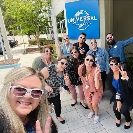 Selfie of Creative Team Members posing with the Universal Creative Logo
