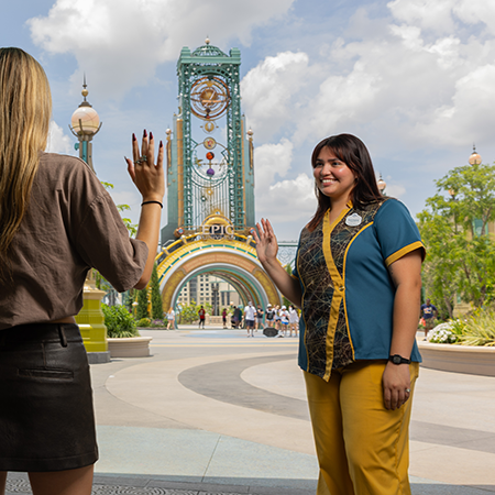 woman waving to a guest at epic universe